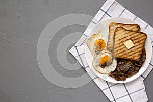 Homemade Healthy Sunnyside Eggs Breakfast on a white plate on a gray background, top view. Flat lay, overhead, from above. Copy