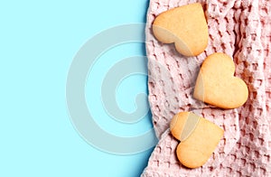 Homemade heart shaped cookies with napkin and space for text on color background