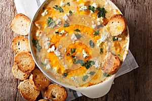 Homemade hot buffalo chicken dip with crostini close up in baking dish. Horizontal top view