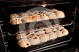 Homemade hot cross buns baking in oven photo