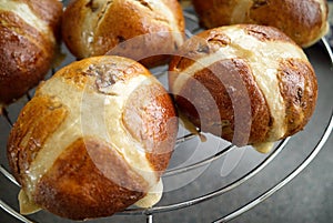 Homemade hot cross buns, cooling on a rack.