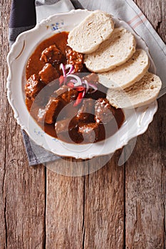 Homemade hot Czech goulash with knodel close-up. vertical top vi photo