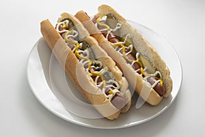 Homemade hot dogs with sausages and pickled cucubers in plate, isolated. White background