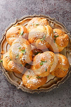 Homemade hot fresh Garlic Knots buns closeup on the plate. Vertical top view