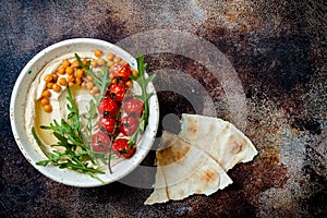 Homemade hummus with roasted cherry tomatoes. Middle Eastern traditional and authentic arab cuisine.