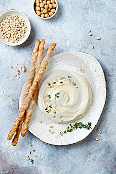 Homemade hummus with thyme, olive oil and pine nuts with grissini bread sticks. Middle Eastern traditional authentic arab cuisine