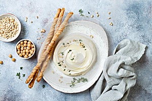 Homemade hummus with thyme, olive oil and pine nuts with grissini bread sticks. Middle Eastern traditional and authentic arab food