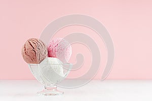 Homemade ice cream scoops various flavor - strawberry, chocolate, creamy in  glass bowl in modern pink color interior on white.