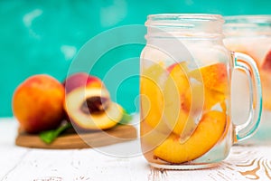 Homemade iced lemonade with ripe peaches. Fresh peach ice tea in a mason jar.