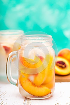 Homemade iced lemonade with ripe peaches. Fresh peach ice tea in a mason jar.