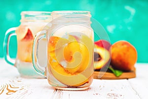 Homemade iced lemonade with ripe peaches. Fresh peach ice tea in a mason jar.