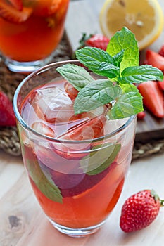 Homemade iced tea with strawberries and mint, vertical, closeup