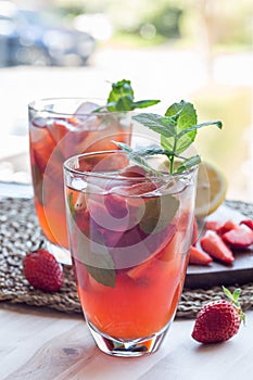 Homemade iced tea with strawberries and mint, vertical