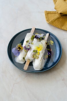 Homemade Indian Rajasthani Kulfi Ice Cream with Stick / Kesariya with Pistachio and Edible Flowers