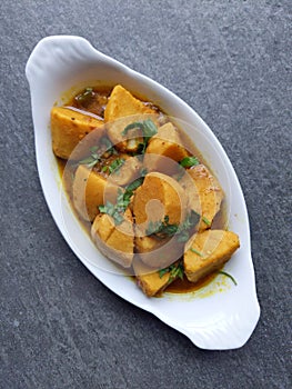 Homemade Indian Taro root  curry or Yam curry on a wooden moody background