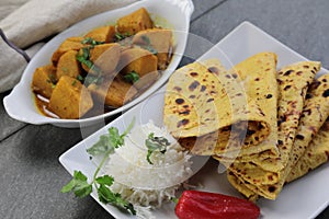 Homemade Indian vegetarian food of Yam or Taroo root curry with gluten free Besan Roti or Chickpea flour Roti on a wooden