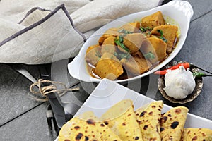 Homemade Indian vegetarian food of Yam or Taroo root curry with gluten free Besan Roti or Chickpea flour Roti on a wooden
