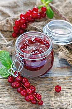 Homemade jam in a jar, red currant and old sacking.