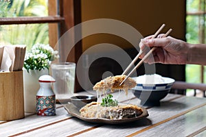 Homemade Japanese deep fried breaded pork tenderloin or cutlet stuffed with cheese, served with tonkatsu sauce.