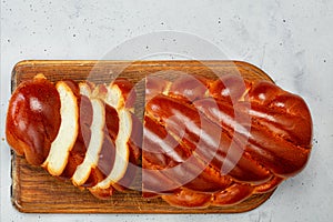 Homemade kalach lies on an old wooden cutting board on a concrete gray background