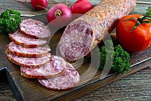 Homemade kraft sausage salami, sliced on a wooden board