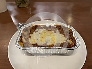 Homemade lasagna in aluminum foil container for takeaway