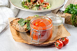 Homemade lecho in a glass jar with a lid filmed in decor