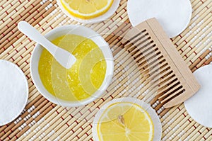 Homemade lemon fruit scrub bath salt, foot soak, facial or hair mask in a small white bowl. Natural beauty treatment, hair care