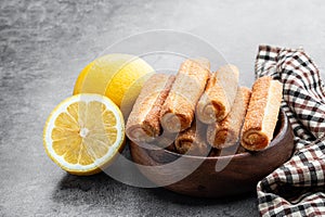 Homemade lemon jam filled sticks in wooden bowl on gray background