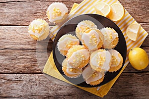 Homemade lemon muffins sprinkled with zest close-up on a plate.