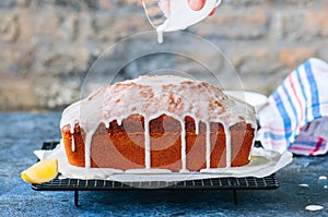 Homemade lemon poppy seed pound cake on a wire rack. Blue stone