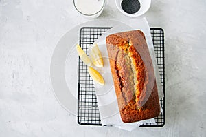 Homemade lemon poppy seed pound cake on a wire rack. White stone