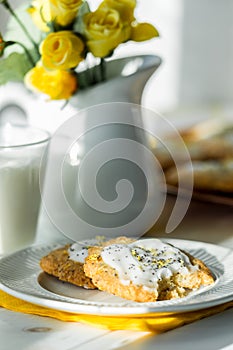 Homemade lemon poppyseed cookies on a table next to a sunny window.