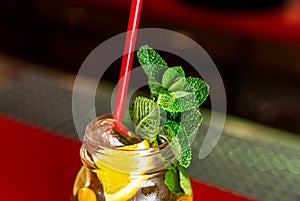 Homemade lemonade ice tea colorful icetea drink with fresh sweet fruits mint leaves in glass on the rocks with straw