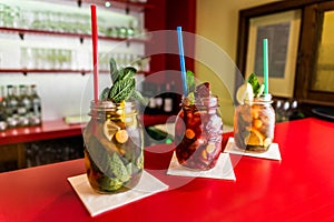 Homemade lemonade ice tea colorful icetea drink with fresh sweet fruits mint leaves in glass on the rocks with straw