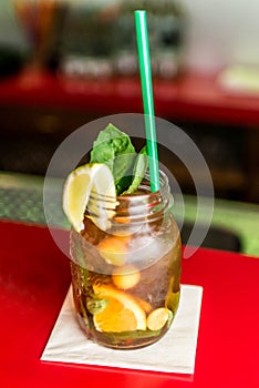 Homemade lemonade ice tea colorful icetea drink with fresh sweet fruits mint leaves in glass on the rocks with straw