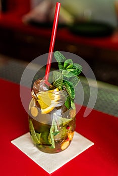 Homemade lemonade ice tea colorful icetea drink with fresh sweet fruits mint leaves in glass on the rocks with straw