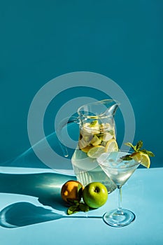 Homemade lemonade with lemon, mint and apple on a blue background