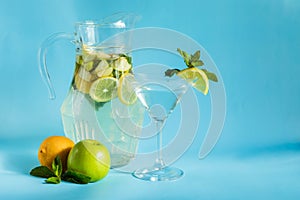 Homemade lemonade with lemon, mint and apple on a blue background