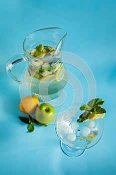 Homemade lemonade with lemon, mint and apple on a blue background