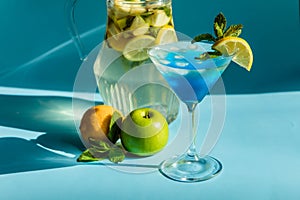 Homemade lemonade with lemon, mint and apple on a blue background