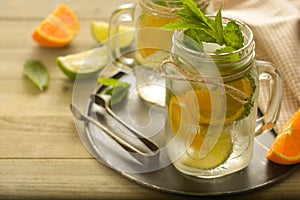 Homemade lemonade with lime, mint in a mason jar on a wooden rustic table. Summer drinks