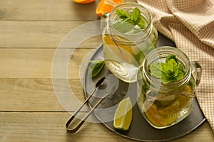 Homemade lemonade with lime, mint in a mason jar on a wooden rustic table. Summer drinks. Copy space