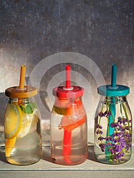 Homemade lemonades in bottles with straws. Lemon, melon and lavender