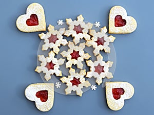 Homemade linzer cookies filled with strawberry jam, small sugar snowflakes around