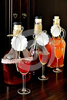 Homemade liqueur in bottles and glasses