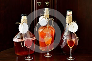 Homemade liqueur in bottles and glasses