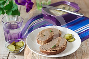 Homemade liver pate with bread and canned cucumber. Rustic style, selective focus.