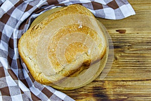 Homemade loaf of bread on wooden table freshly baked in an electric bread maker. Homemade baking