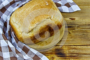 Homemade loaf of bread on wooden table freshly baked in an electric bread maker. Homemade baking